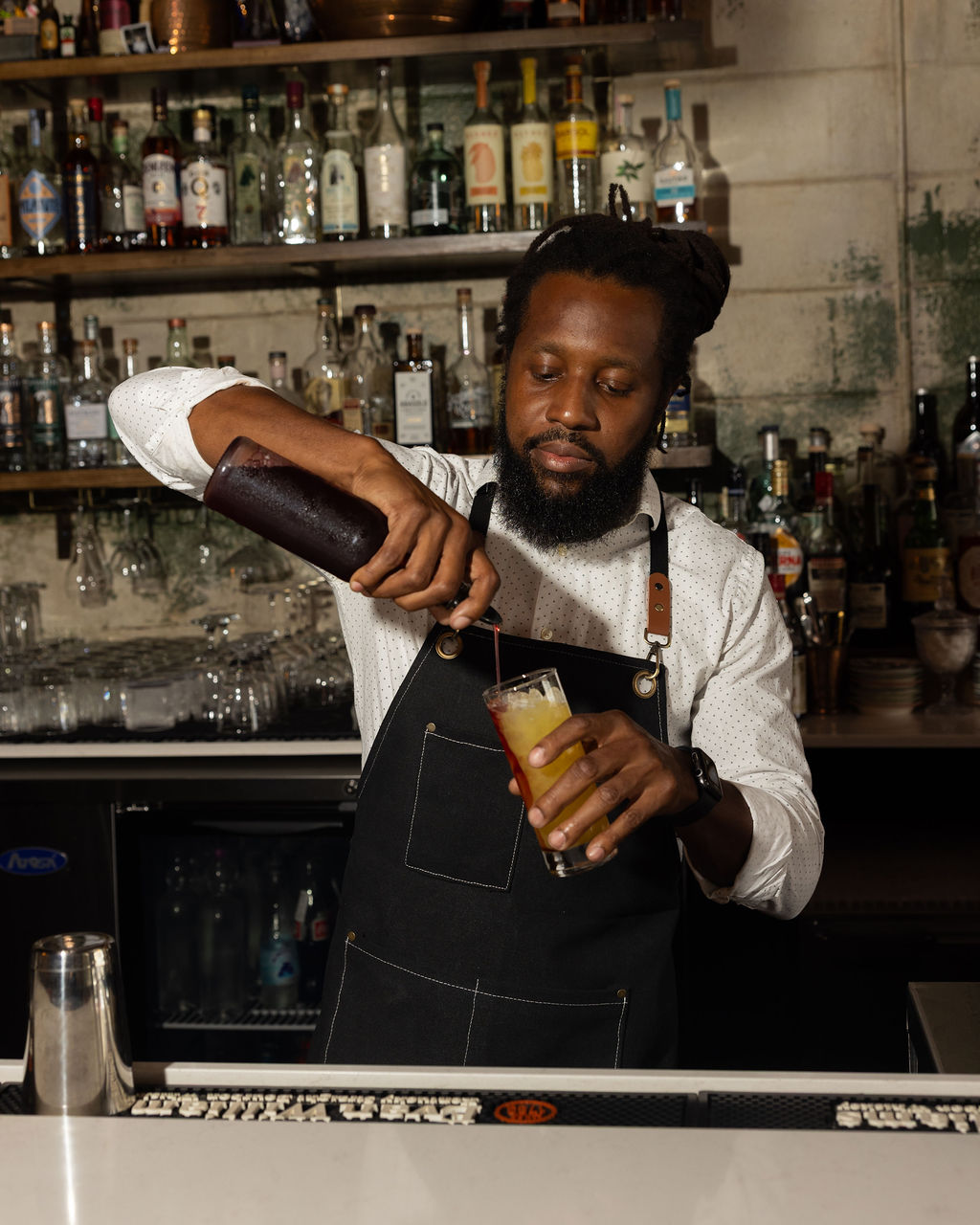 Daniel pouring a cherry shrub into a citrus cocktail